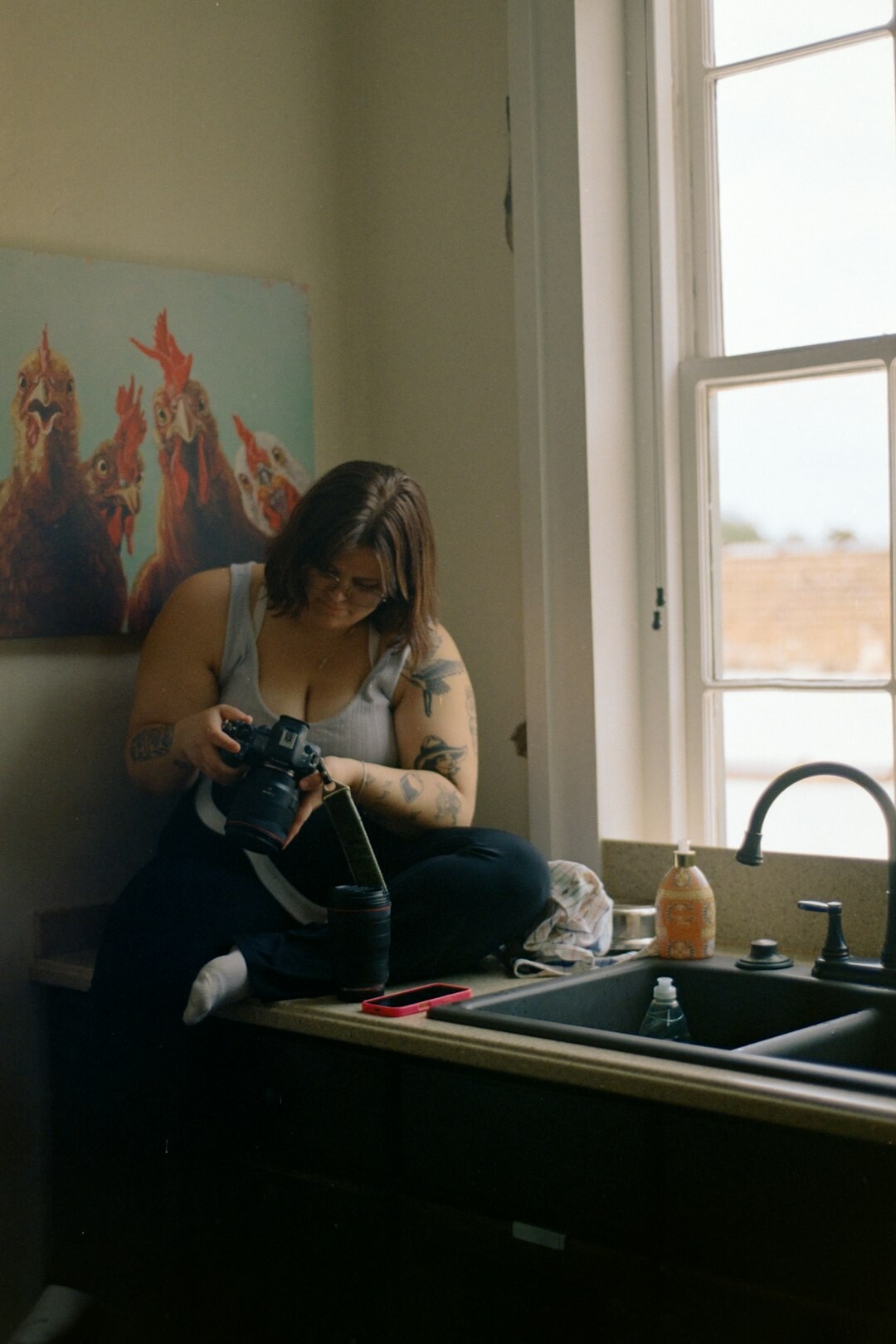 Documentary photographer reviewing photos on a laptop in a home studio