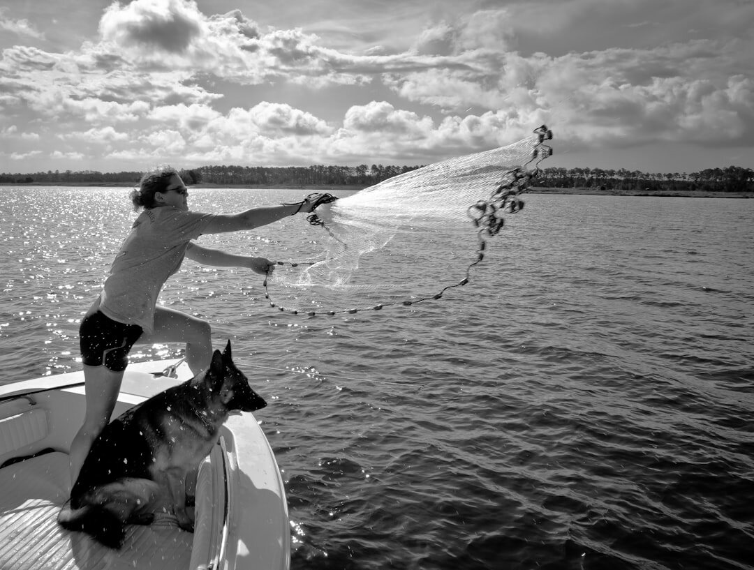 fisherman pulling net from sea