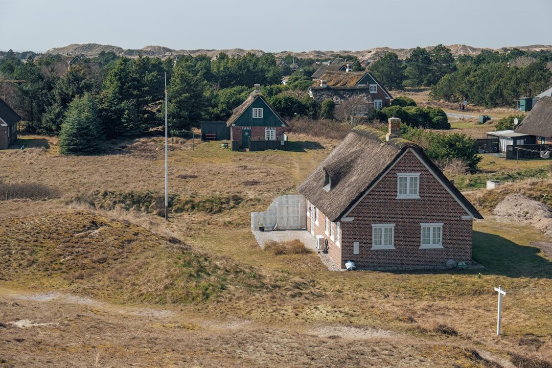 Photographer walking through a Danish village carrying camera equipment